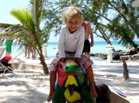 Child on Rum Point Beach riding Iguana